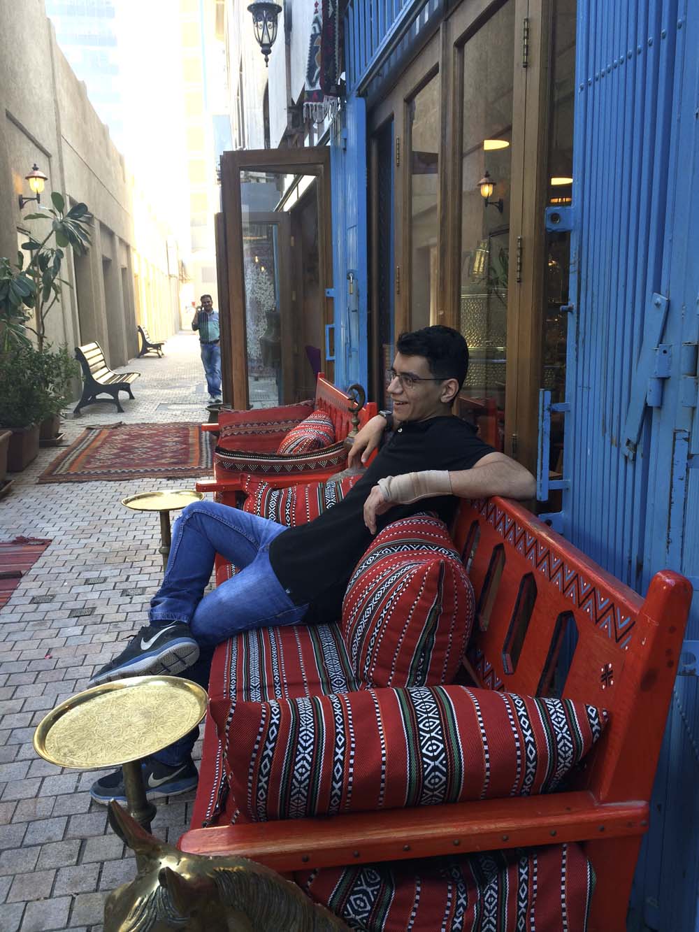 while yousef sits on a more practical bench with traditional sadu cushions