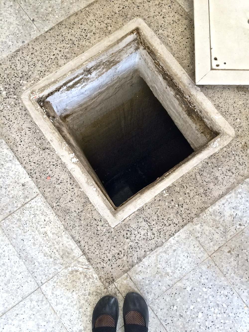 and in the floor is this: one of a few wells scattered around the courtyard. of course this is covered by the lid you see in the top right corner. either way, i'd be terrified to have something like this in my courtyard