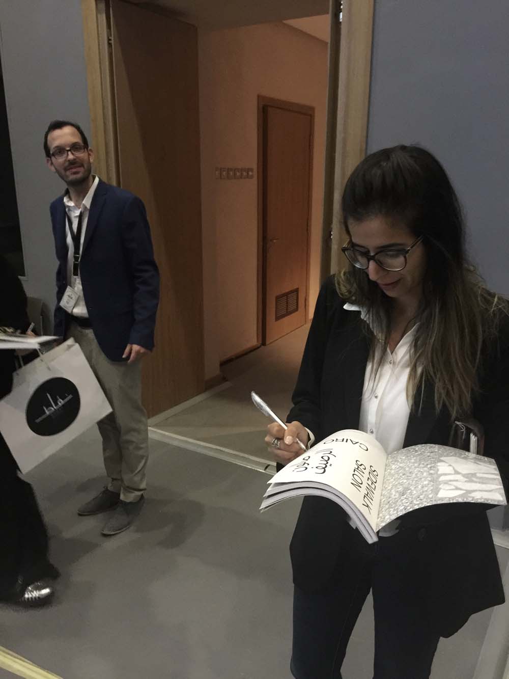 i buy three copies of their book (and feel like a huge hog because i find out later that they only brought ten copies with them). here manar signs my copy